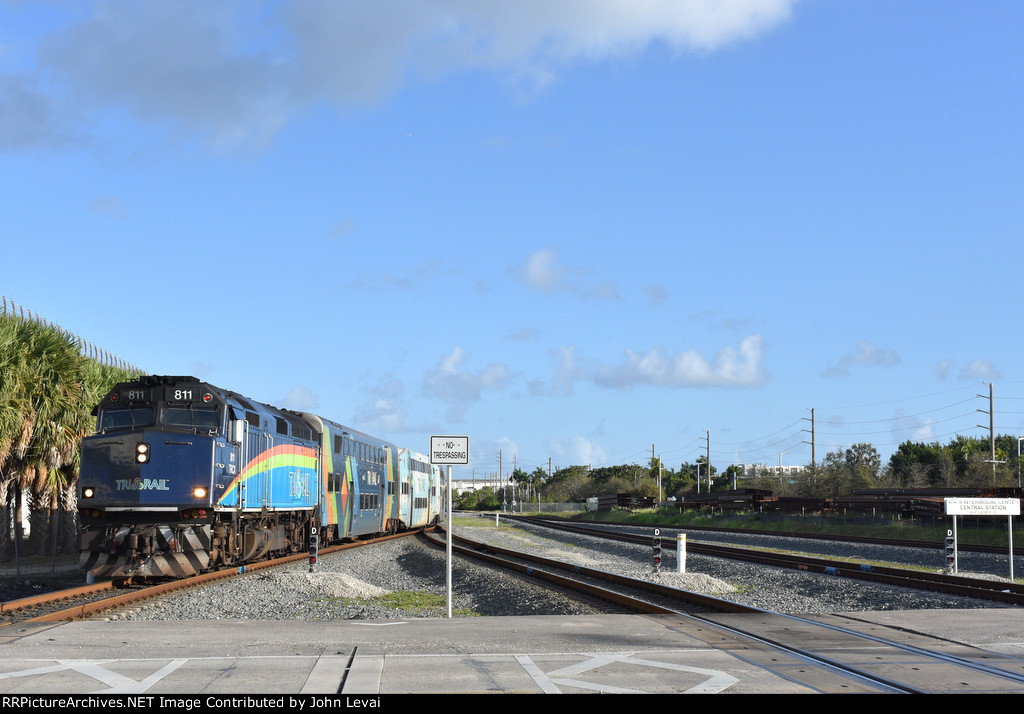 Tri-Rail Train # P663 is about to cross NW 25th Street at grade before finishing its journey at Miami Airport(Miami Intermodal Center Station). F40PH-3C # 811 is the power for the train.